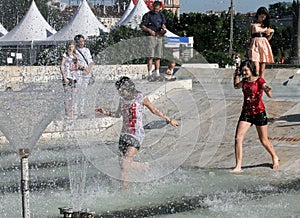 Kids play in a water of a fountain on a sunny summer day during summer break in Sofia, Bulgaria Ã¢â¬â june 15, 2012. Sunny weather c